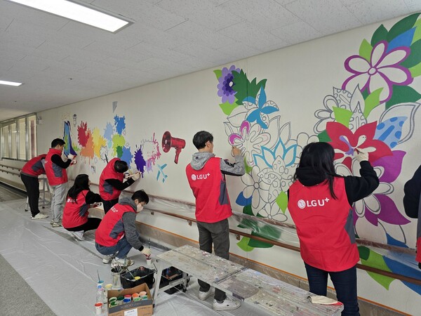 ▲수원 아름학교에서 LG유플러스 임직원들이 벽화그리기 봉사활동을 진행하고 있는 모습.ⓒLG유플러스