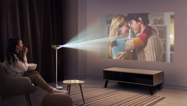 ▲프로젝터에 인테리어 조명, 스피커를 결합한 3-in-1 형태의 신개념 프로젝터(PF600U)로 대화면 콘텐츠를 감상하는 모습. ⓒLG전자