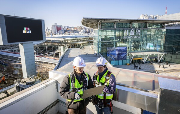 ▲SKT와 SK오앤에스 엔지니어가 서울역 인근에서 통신장비를 점검하는 모습ⓒSK텔레콤