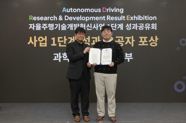 ▲지난 4일 일산킨텍스에서 열린 ‘자율주행기술개발혁신사업’ 1단계 성과공유회에서 카카오모빌리티 홍승환 책임연구원(오른쪽)이 수상 후 과학기술정보통신부 송창종 디바이스AX혁신팀장(왼쪽)과 기념사진을 촬영하고 있다. ⓒ카카오모빌리티