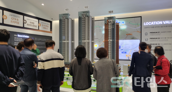 ▲방문객들이 견본주택 1층 디오라마 앞에서 관계자 설명을 듣는 모습. ⓒ최나리 기자