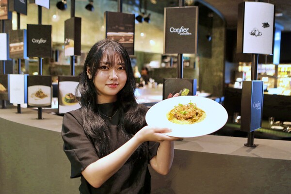 ▲잠실 롯데월드몰 6층 콘피에르 셀렉션에서 음식을 들고 있는 모델의 모습. ⓒ롯데백화점