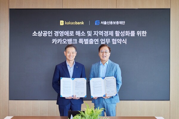 ▲지난 25일 경기도 성남시 카카오뱅크 판교오피스에서 진행된 '카카오뱅크 특별출연 업무 협약식'에서 윤호영 카카오뱅크 대표이사(오른쪽)와 최항도 서울신용보증재단 이사장이 참석해 기념 촬영을 하고 있다. ⓒ카카오뱅크