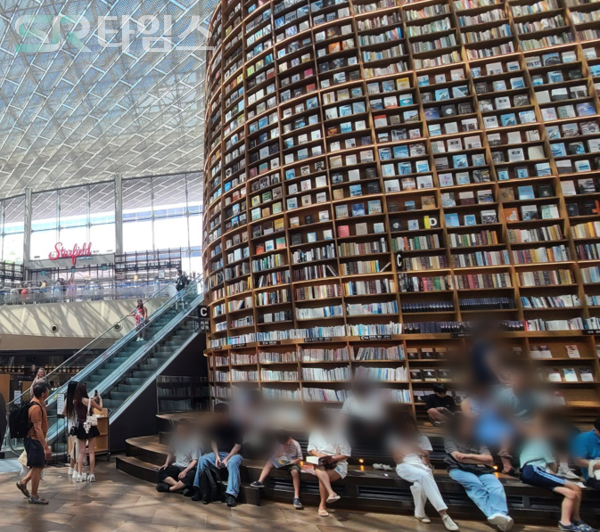 ▲대형서가 아래 휴식을 취하는 사람들. ⓒ박현주 기자