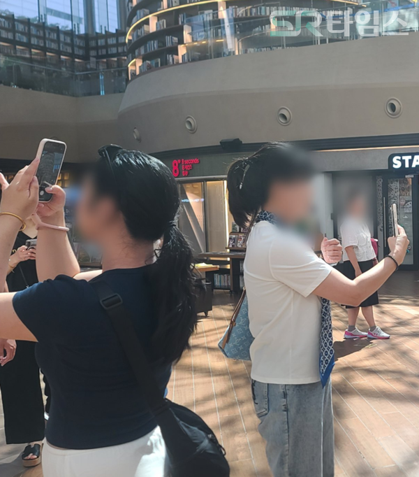 ▲별마당 도서관 대형서가 앞 곳곳에서 사진을 찍고 있는 방문객 모습. ⓒ박현주 기자