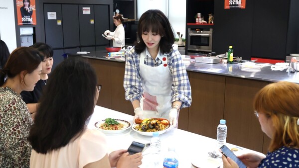 ▲롯데홈쇼핑은 지난 18일 배우 이유리의 '요즘쇼핑 유리네' 론칭 1주년을 기념해 고객 초청 쿠킹클래스를 진행했다. 사진은 배우 이유리가 조리한 음식을 고객들에게 직접 전달하는 모습. ⓒ롯데홈쇼핑