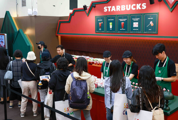 ▲美지엄 행사장에서 미리 만나는 크리스마스를 콘셉트로 부스를 운영 중인 스타벅스가 30일 출시 예정인 크리스마스 프로모션 음료를 고객에게 제공하는 모습. ⓒ스타벅스