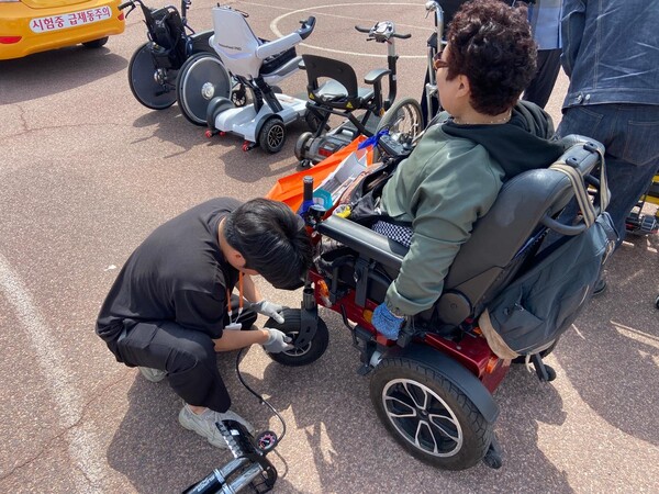 ▲장애인보조기기 수리지원(전동휠체어 타이어 교체) 작업 모습. ⓒ부산광역시