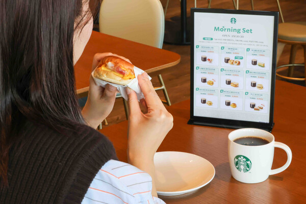 ▲고객이 '모닝 세트'로 구입한 '베이컨 체다 & 오믈렛 샌드위치'와 '카페 아메리카노'를 즐기는 모습. ⓒ스타벅스