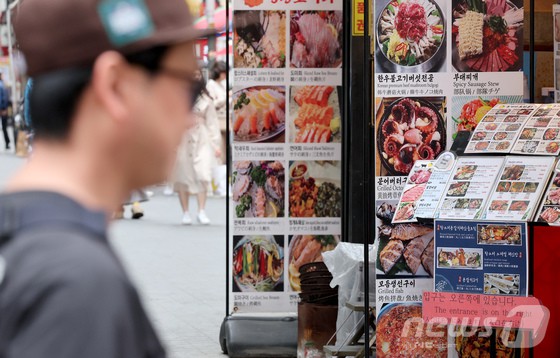서울 중구 명동거리 식당가에 관광객들이 지나가고 있다.