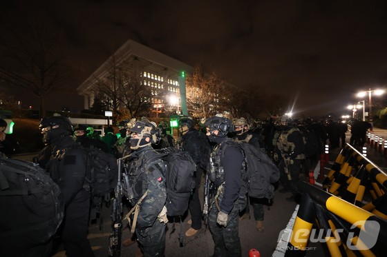 윤석열 대통령의 비상계엄 해제 요구 결의안이 국회 본회의에서 통과된 4일 새벽 무장 계엄군이 국회를 나서고 있다.