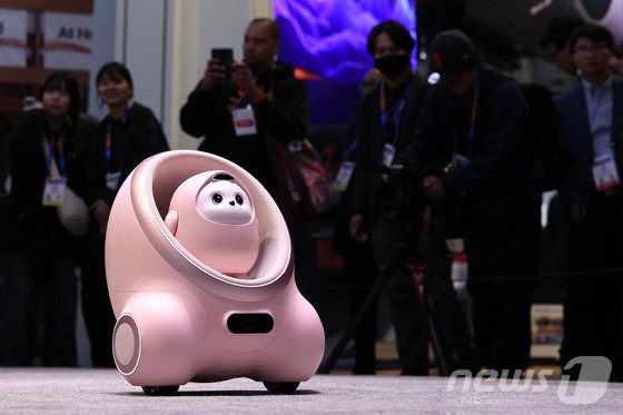 세계 최대 정보기술(IT)·가전 전시회 'CES 2025' 개막일인 7일(현지시간) 미국 네바다주 라스베이거스 컨벤션센터(LVCC)에 마련된 중국기업 TCL 부스에서 관람객들이 인공지능(AI) 로봇 에이미(AiMe)를 살펴보고 있다.